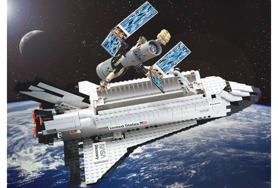 LEGO set 7470 Space Shuttle Discovery from 2003, a white shuttle orbiter with a small, simplified Hubble Space Telescope model positioned above its open cargo bay.